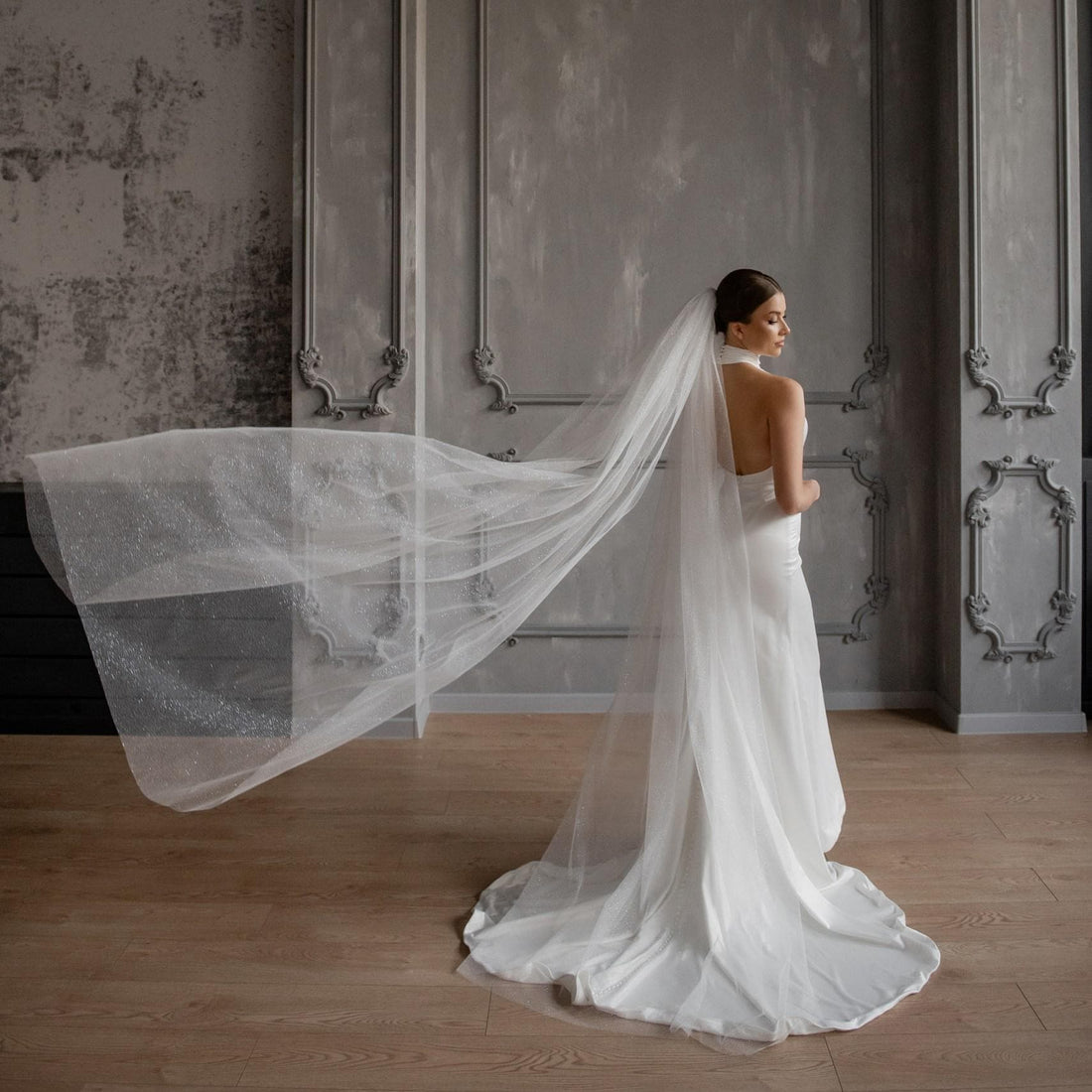 Bride wearing a long wedding veil with a white wedding dress